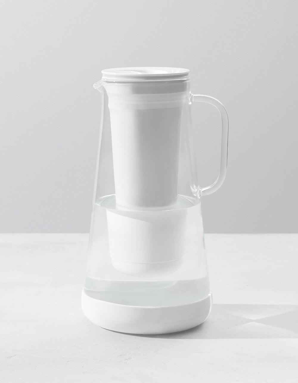 LifeStraw Home 7-Cup Glass pitcher with white lid, housing and silicone base; official studio render.